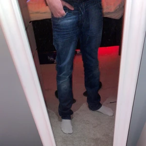 Blå jeans från Nudie Jeans - Säljer ett par snygga blå jeans från Nudie Jeans i bra skick. De har en klassisk femficksdesign och en bekväm passform. Perfekta för både vardag och fest! 🕺