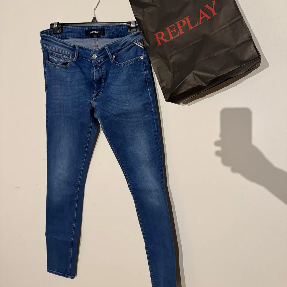 Säljer ett par snygga blå jeans från Replay i mycket bra skick. De är tighta och har en klassisk femficksdesign med dragkedja och knapp framtill. Perfekta för både vardag och fest!. Jeans & Byxor.