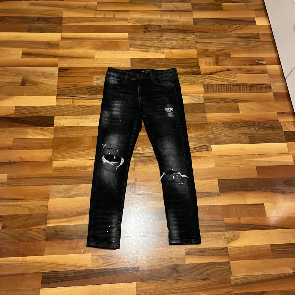 Säljer ett par svarta jeans från Supply & Demand i storlek S. De har coola slitningar på knäna och en snygg tvättad look. Perfekta för en avslappnad stil eller en utekväll. Tillverkade i Pakistan.. Jeans & Byxor.