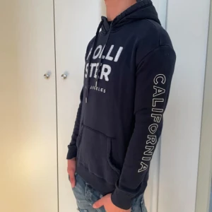 Mörkblå hoodie med tryck - Säljer min riktigt snygga mörkblå hoodie från märket hollister. Den är sparsamt använd och har inga defekter. Hör av dig vid eventuella frågor. FRAKTAR SNABBT 📦📦