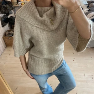 Beige stickad tröja med bred krage - Säljer en supermysig beige stickad tröja med en bred krage som kan bäras off-shoulder. Perfekt för höst och vinter! Tröjan har trekvartsärmar och gör den både bekväm och stilren. Man kan ha på olika sätt! Den är i jätte bra kvalitet❤️