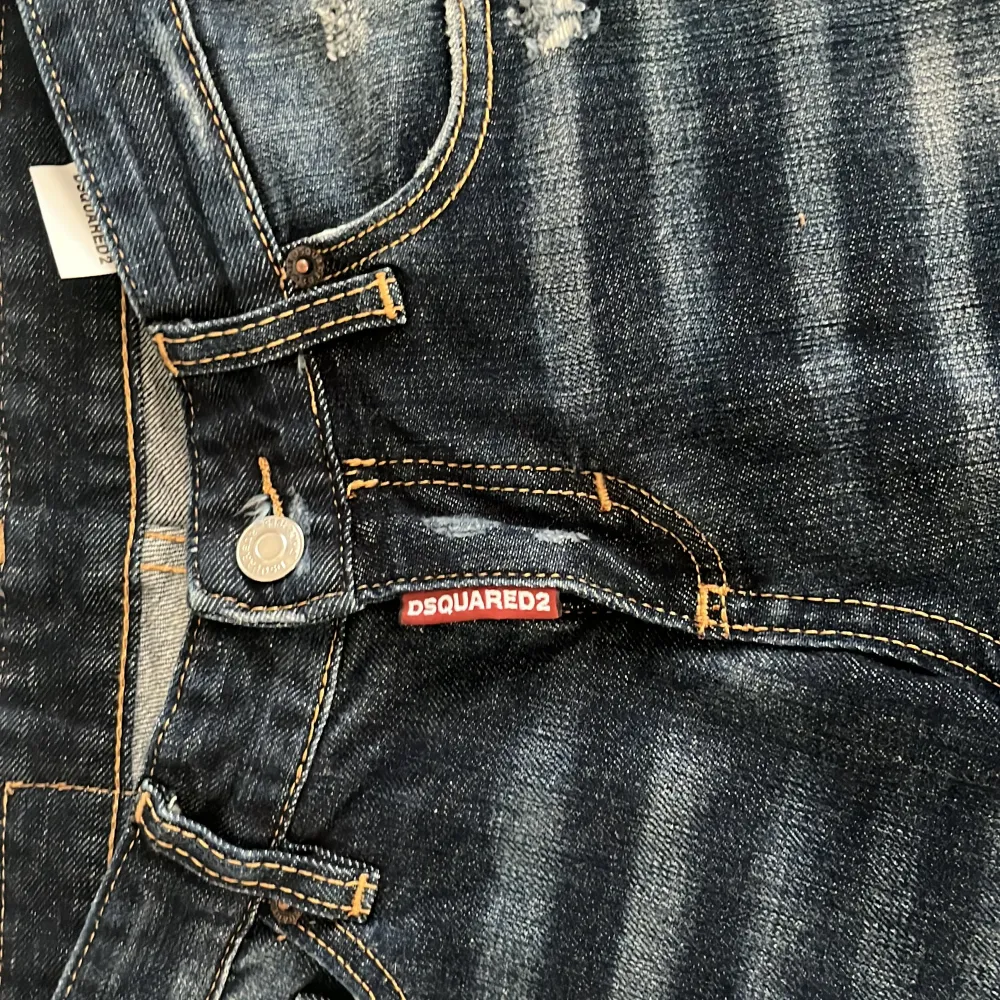 Säljer ett par snygga mörkblå jeans från Dsquared2 i bra skick. De har en cool slitningseffekt och är i en straight stil. Perfekta för en avslappnad look med en touch av edge. Passar bra till både vardag och fest! Det är helt nya . Jeans & Byxor.