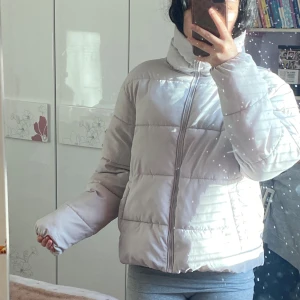 Vit pufferjacka - Säljer en supermysig vit pufferjacka i bra skick. Den har en dragkedja framtill och långa ärmar, perfekt för kyliga höst- och vinterdagar. Jackan är i en normal passform och håller dig varm och bekväm. Perfekt för både vardag och chill häng!