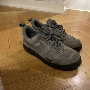 Grå Nike Air Force  - Säljer ett par grå Nike Air Force i mocka. Har använt de men är fortfarande i bra skick. Storlek 40, köpte de för 1250