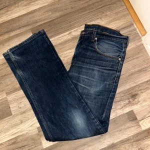 Levi's 752 jeans i mörkblå denim - Säljer ett par Levi's 752 jeans i mörkblå denim. De har en klassisk femficksdesign och är i bra skick. Perfekta för både vardag och fest. stilrena jeans som passar till det mesta!