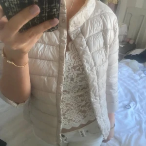 Beige trekvarts jacka  - Säljer en snygg beige pufferjacka i mycket bra skick. Jackan har en stilren design med knappar framtill och är perfekt för höst och vår. Den är trekvartsärmad och har en normal passform, vilket gör den lätt att matcha med olika outfits.