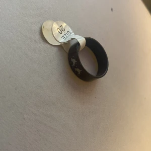 Svart ring med delfinmönster - Cool svart ring i storlek 20 med ett subtilt stjärnmönster runt om. Perfekt för att ge din outfit en unik touch. Passar både till vardags och festliga tillfällen. 🖤den är aldrig använd jag har bara hållit i den. Kan passa perfekt som en julklapp! Och jag vann den och då kostade den 250kr att köpa och jag säljer den för endast 70kr!