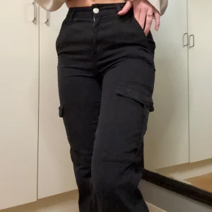 Svarta cargobyxor - Säljer ett par svarta cargopants från pull & bear. De har en hög midja och fickor på sidorna. 