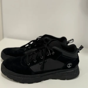 Svarta sneakers från Timberland - Säljer ett par snygga svarta sneakers från Timberland i storlek herr 45. Skorna är i mocka och har en stilren design med snörning. Perfekta för både vardag och festliga tillfällen. De är i mycket bra skick och redo för nya äventyr!