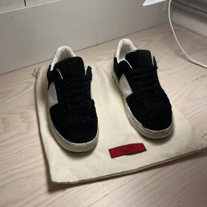 Valentino flycrew - Säljer ett par snygga svarta sneakers från Valentino i bra skick. De har en vit sula och vita detaljer på sidorna. Perfekta för både vardag och fest! Kommer med originalpåse. Skicket är cirka 7/10!👍