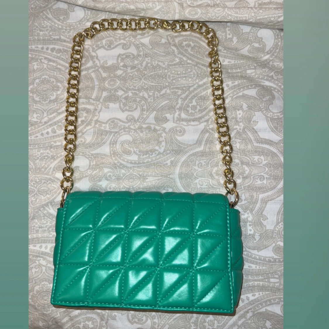 Turkos quiltad axelväska med guldkedja