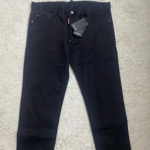 Svarta jeans från Dsquared2 - Säljer ett par snygga svarta jeans från Dsquared2. De har en klassisk femficksdesign och är i nytt skick. Perfekta för både vardag och fest. Märkeslapparna sitter kvar, så de är helt oanvända. Passar perfekt för dig som vill ha stilrena och bekväma byxor.