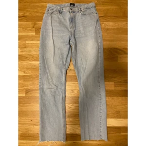 Ljusblå jeans med rå kant - Säljer ett par ljusblå jeans i bra skick. De har en straight passform och är högmidjade med en cool rå kant nertill.