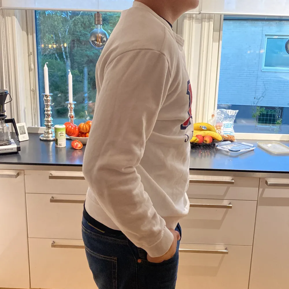 Säljer en snygg vit sweatshirt från Lee med deras klassiska logga i rött och blått på framsidan. Tröjan är långärmad och perfekt för en casual look. Den är i storlek L och i bra skick. Perfekt för höst och vår!. Hoodies.