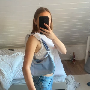 Ljusblå axelväska med dragkedja och lite mus färgad med gul - Lite mis färgad i gul