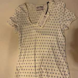 Vit och blåmönstrad topp från Holly & Whyte - Jättefin topp från Holly & Whyte som tyvärr aldrig kommit till användning då det inte är min stil längre. Helt ny med prislappen kvar, endast provad.