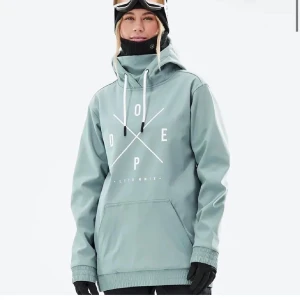 Grön skidjacka från Dope - Snygg grön skidjacka från Dope med stor logga framtill. Den har en hög krage med snörning och en stor magficka. Perfekt för kyliga dagar i backen. 💖🌟❄️