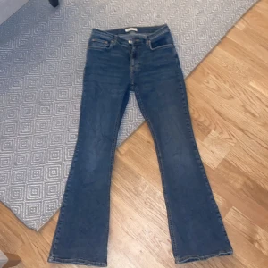 Blå bootcut jeans från Gina tricot - Säljer ett par snygga blå bootcut jeans från Gina tricot. De har en klassisk femficksdesign och är mid rise  för en bekväm passform. Perfekta för en vanlig dag.