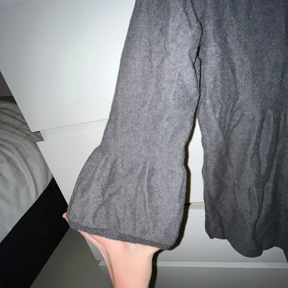 Mysig grå kofta från Lindex med knappar framtill. Den har en avslappnad passform och trekvartsärmar, perfekt för kyligare dagar. Koftan är tillverkad i ett mjukt material som ger en bekväm känsla.. Neuletakit & Villapaidat.