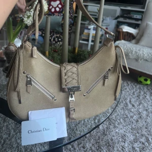 Dior suede admit bag - Snygg beige axelväska från Christian Dior i mocka med flätade detaljer och silverfärgade dragkedjor. Väskan har en justerbar axelrem och är köpt begagnad från Vestaire med äkthetsbevis🥳