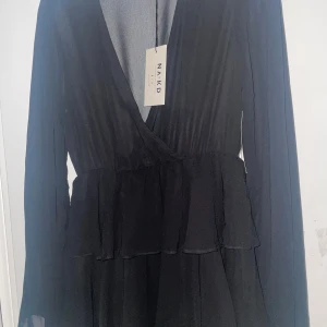 Svart omlottklänning från Na-Kd - Säljer en svart volangklänning från nakd. Den är i strl 36. För mig med 32 är den lite stor och säljer därför den. Om ni tycker det är dyrt kan jag sänka priset ganska mycket. Den är helt ny med lapp