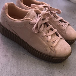 Rosa k. Cobler skor med brun sula - Snygga rosa sneakers i mocka med snörning och en trendig platåsula. Helt oanvända så i väldigt fint skick. Säljer då de tyvärr är för stora för mig