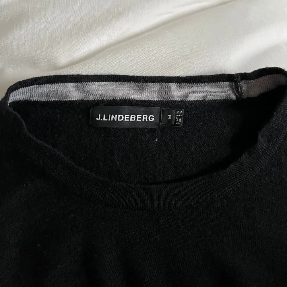 Snygg svart merinoull tröja från J.Lindeberg med diskret logga på bröstet. Perfekt för en stilren look. Knappt använd! Storlek M men passar även S! Modellen på bilden är 180. Bättre pris vid snabb affär🙌🏽. Neuletakit & Villapaidat.