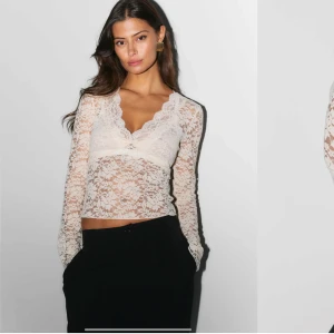 Vit spetsblus med v-ringning - Elegant vit spetsblus med v-ringning och långa ärmar. Perfekt för en stilren look med sitt genombrutna spetsmönster. Blusen har en figurnära passform och är ett måste i garderoben för den som älskar romantiska detaljer. 