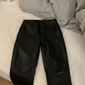 Svarta skinnbyxor från BikBok - Snygga svarta lågmidjade skinnbyxor från BikBok i storlek 38, de är helt oanvända och perfekta att ha nu till vintern, jag säljer dem då de var för stora för mig, jag skulle rekommendera att man går upp en storlek om man köper dem (alltså passar dessa folk som vanligtvis har ca stl 36 på byxor)💕💕