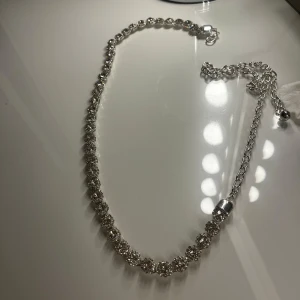 Glittrigt skärp i silver - Snyggt och elegant skärp i silver med glittrande stenar. Perfekt för att ge en extra touch till din outfit. Justerbar längd med kedja och lås. Jättefint att ha runt midjan på byxor eller klänning för att piffa upp sin outfit