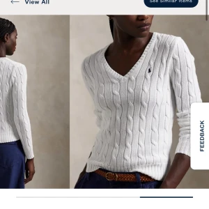 Vit kabelstickad tröja från Ralph Lauren - Vit kabelstickad tröja från Ralph Lauren med v-ringning och långärmade design. Tröjan har en liten broderad logotyp på bröstet och ribbade muddar vid ärmslut och nederkant. Perfekt för en stilren och klassisk look. ( og: 2395kr )