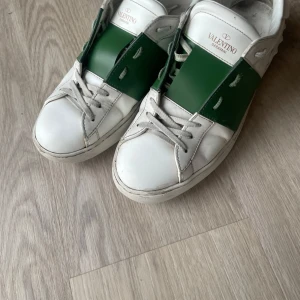 Valentino opens - Snygga Valentino opens i vitt med gröna detaljer. Skorna har en stilren design med snörning och är perfekta för en trendig look. Märkesloggan syns tydligt på plösen. Skorna tillkommer också med en ny snörning , skopåsar och en box. Pris kan diskuteras 