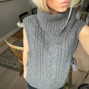 Stickad väst/pullover - Stickad väst/pullover med knytning på sidan, som tyvärr inte kommer till användning längre. Jätte fint skick! Skriv för fler bilder🩷