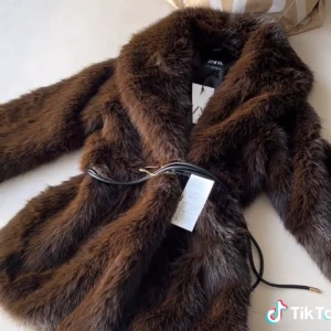 Brun pälsjacka från Zara - Snygg brun pälsjacka från Zara med ett elegant bälte i midjan. Jackan har en lyxig look och är perfekt för kyligare dagar. Den har långa ärmar och en mjuk, fluffig textur som ger en exklusiv känsla. Jackan kommer inte till användning och därav är den i ett helt nytt skick. Pris går att diskutera.