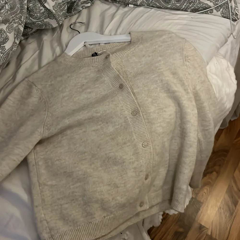 Mysig beige kofta med knappar framtill. Perfekt för kyliga dagar med sin mjuka och bekväma passform. Ett stilrent plagg som passar till det mesta. Storleken är M men passar mig jätte fint som är en xxs/xs/S. Neuletakit & Villapaidat.