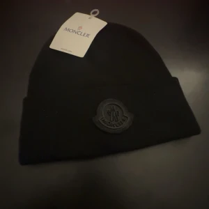 Ny fet Moncler mössa - Tja! Säljer denna tvär feta mössan från Moncler, riktigt najs till kyliga vinter dagar, mössan är generellt tvär fet och den svarta loggan gör bara mössan ännu fetare