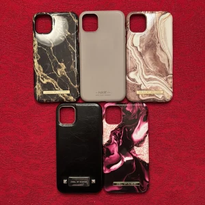 Mobilskal IPhone 11 - Säljer fyra snygga mobilskal från Ideal of Sweden och ett ett från holdit. Skalen har olika mönster och färger: ett svart med guldmarmor, ett beige, ett med brun marmor, ett helsvart och ett med rosa och svart marmor. Perfekt för att ge din mobil en ny look!