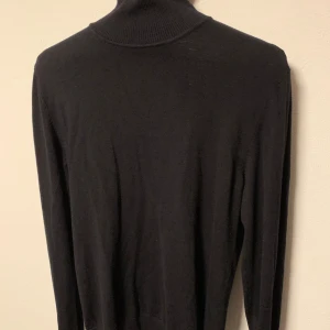 Svart polotröja från Lindbergh - Säljer en stilren svart polotröja med långa ärmar. Perfekt för kyligare dagar och enkel att matcha med olika outfits. Storlek S.