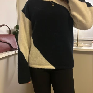 Svart och vit stickad tröja - Säljer en mysig stickad tröja i svart och vitt med ett unikt mönster. Tröjan har långa ärmar och en bekväm passform. Perfekt för kyligare dagar!
