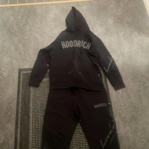 Svart hoodie från Hoodrich - Säljer en svart hoodie från Hoodrich med texten 'FROM NOTHING TO SOMETHING' på ryggen. Hoodien har en klassisk design med huva och långa ärmar. Perfekt för en avslappnad stil. 