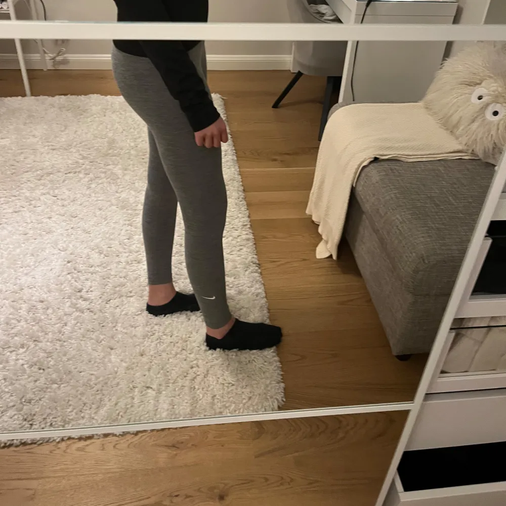 Säljer ett par grå leggings från Nike i Dri-FIT material. De är högmidjade och har en tight passform, perfekta för träning. Leggingsen är tillverkade i ett syntetmaterial som andas och håller dig torr under intensiva pass.. Farkut & Housut.