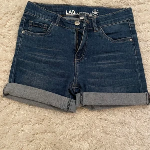 Mörkblå jeansshorts från LAB Industries - Säljer dessa supersnygga mörkblå jeansshorts från LAB Industries. Shortsen har uppvikta kanter och klassisk femficksdesign. Perfekta för en avslappnad stil. OBS! Kanter kan vikas upp och ner beroende på hur man vill ha dem🩷 säljer pga att dem är för små. Strl:152🩷 köpare står för frakten!