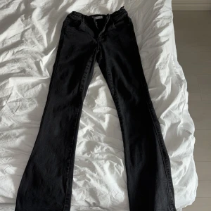 Svarta jeans - Snygga svarta jeans från Name It med klassisk femficksdesign. De har en knapp och dragkedja framtill och är perfekta för en stilren look. Midjan är justerbar och är storlek 164/14 år 🩷