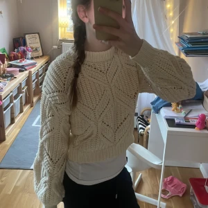 Beige stickad tröja från Nooloola - Säljer en snygg beige stickad tröja från Nooloola. Tröjan har ett unikt stickmönster med långa ärmar och ribbade muddar. Ganska kort på mig! Men blir jätte snyggt med linne under!
