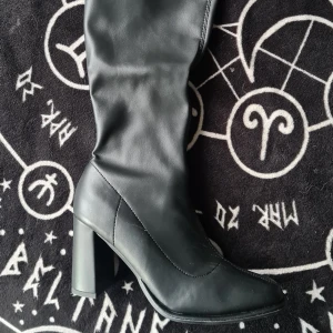 Svarta stövlar med klack - Snygga svarta stövlar i skinn med hög klack. Perfekta för en stilren look. De har en elegant design som passar till många olika outfits. Helt nya och oanvända.