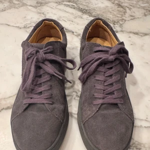 Grå mockasneakers med snörning - Snygga grå sneakers i mocka med klassisk snörning från Myrqvist. De har en stilren design med en bekväm innersula. Perfekta för en avslappnad stil men även för finare sammanhang.