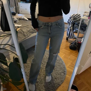 Blå jeans med slitningar från Ginatricot  - Jeans med slitningar från Ginatricot. Fick dom av en kompis men har aldrig kommit till användning. 