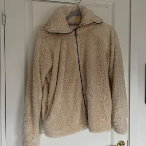 Beige teddyjacka från Undiz - Mysig beige teddyjacka från Undiz i storlek S. Jackan har en dragkedja framtill och är långärmad, perfekt för kyliga dagar. 