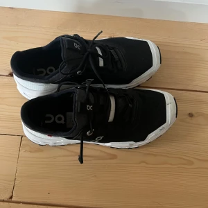 Svarta och vita sneakers från On  - Säljer ett par snygga svarta och vita sneakers från On. Modell cloud ultra  Skorna har en modern design med snörning och en bekväm sula. Perfekta för både träning och vardag.i nyskick endast prov gådda 