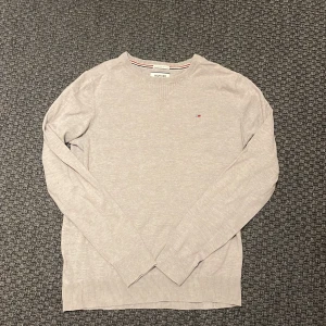 Grå tröja från Hilfiger Denim - Säljer en stilren grå tröja från Hilfiger Denim. Tröjan har långa ärmar och en liten logotyp på bröstet. Perfekt för en avslappnad look. Skriv vid funderingar 💭🤩